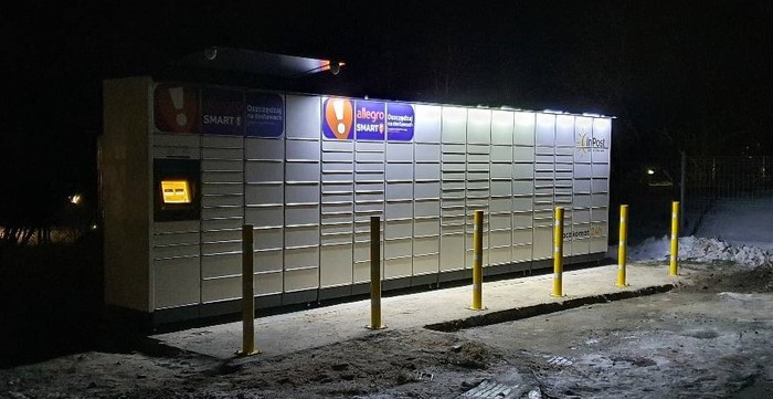 Paczkomat SPR01M Na parkingu dla pracowników, za sklepem Delikatesy Centrum