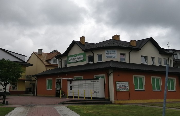 Paczkomat SSW03N Po prawej stronie od wejścia do sklepu Delikatesy Centrum