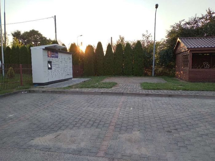 Paczkomat SUQ01M Przy stacji paliw Huzar, po lewej stronie, obok ławek