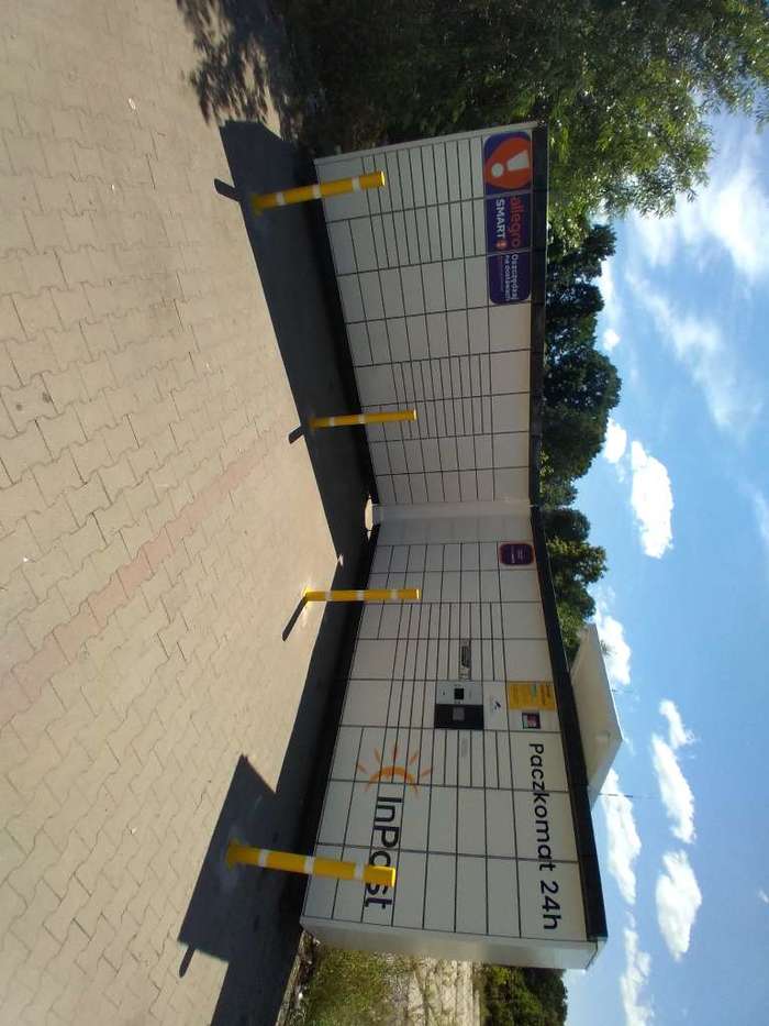 Paczkomat SWA01N Przy parkingu sklepu budowlanego.