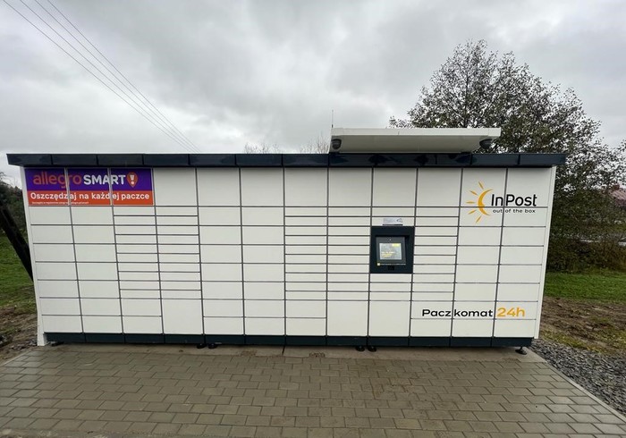 Paczkomat TEQD01M na parkingu obok sklepu