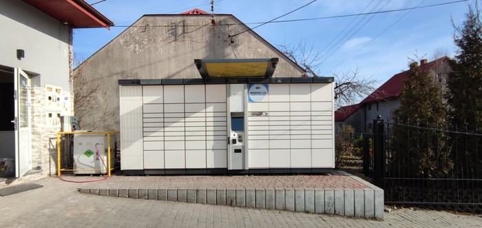 Paczkomat TRK01A Z prawej strony przed budynkiem