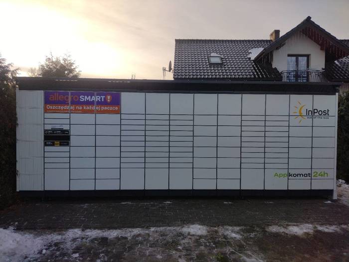 Paczkomat TWO01BAPP na parkingu przy sklepie monopolowym