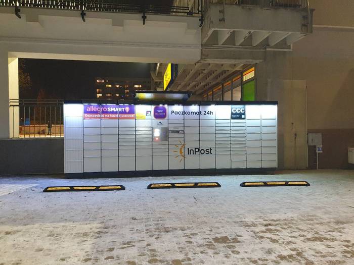 Paczkomat TYC09N na bocznym parkingu, obok apteki