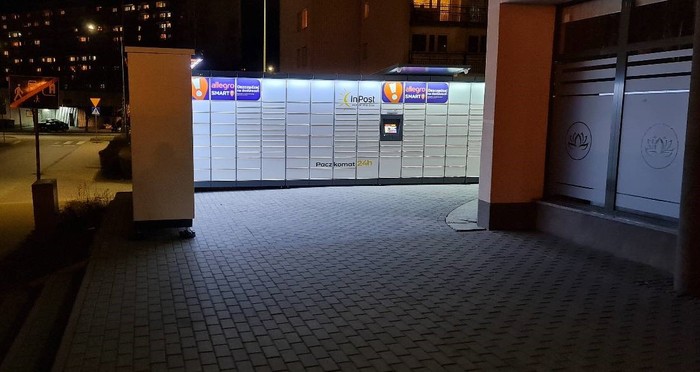 Paczkomat WAL16M Po lewej stronie od wejścia.