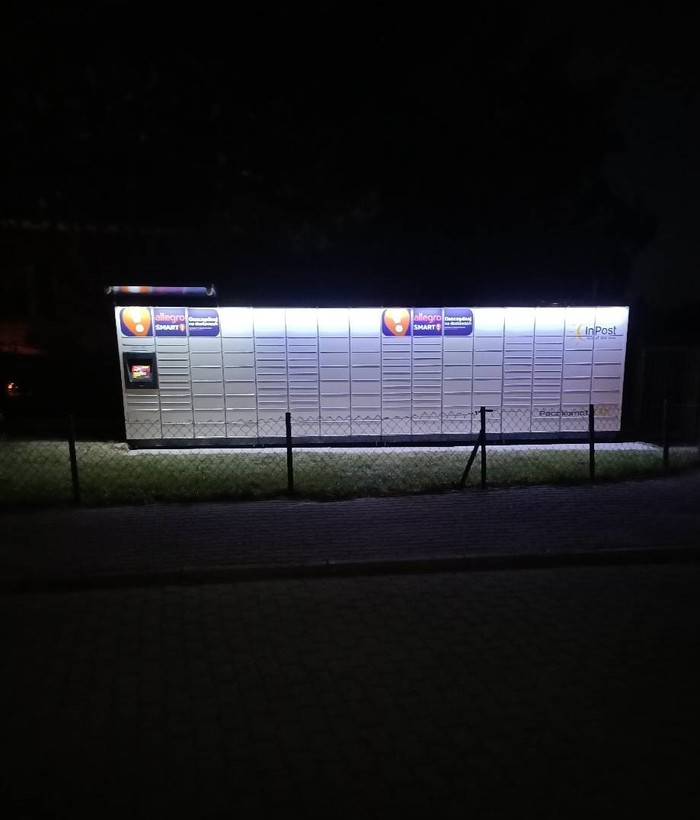 Paczkomat WAW418M na trawniku przed pływalnią od strony ul Wolfkego
