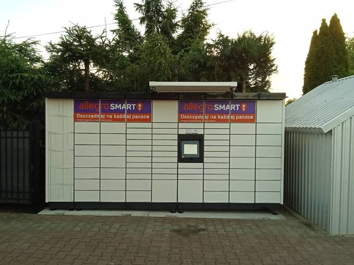 Paczkomat WAWA01M Na parkingu przy sklepie spożywczym