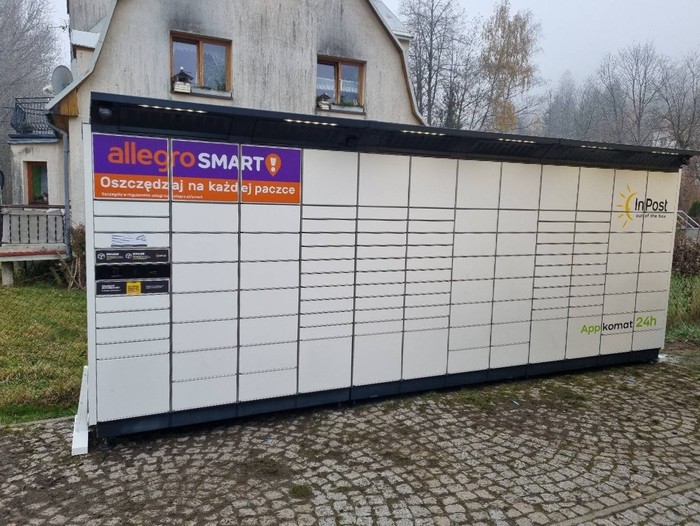 Paczkomat WIS02BAPP na parkingu obok sklepu