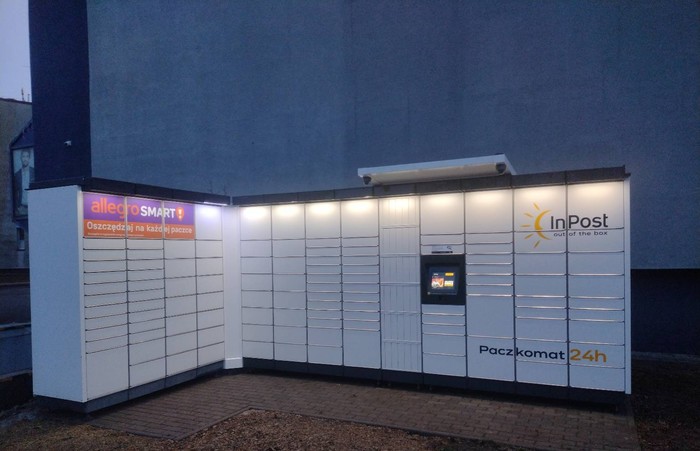 Paczkomat WOD21M obok parkingu sklepu odzieżowego SUMMER-CHA