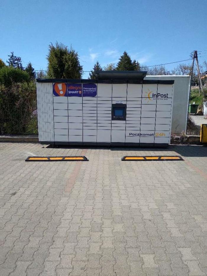 Paczkomat WOW01M Po lewej stronie od wejścia, przy parkingu.