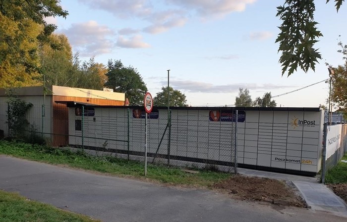 Paczkomat WRO107M W ogrodzeniu parkingu od strony osiedla