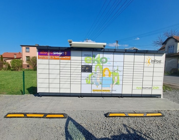 Paczkomat WUP01APP Na parkingu przed budynkiem