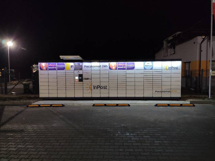 Paczkomat XIC01N Na parkingu przed sklepem
