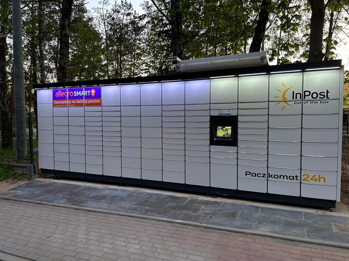 Parcel Locker XUW01M Przy Szkole Podstawowej, w płocie po lewej stronie od wjazdu