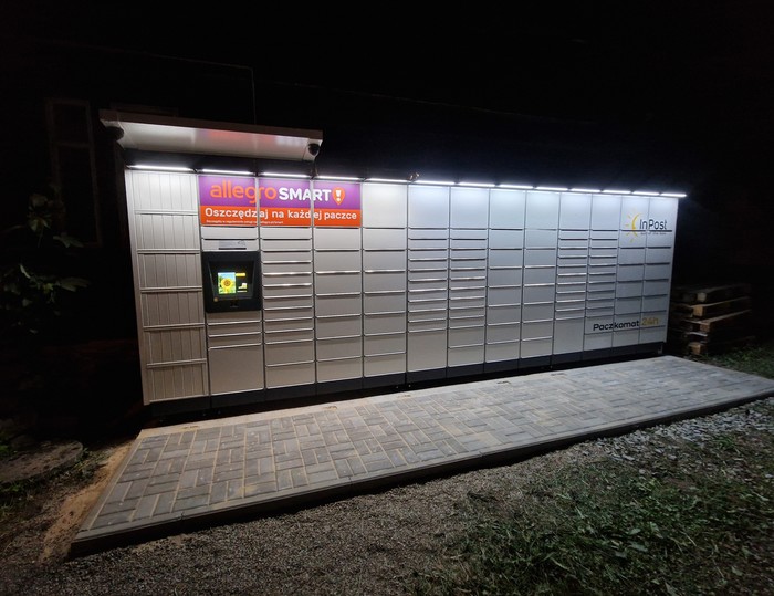 Paczkomat ZAK15M Na parkingu obok starego domu